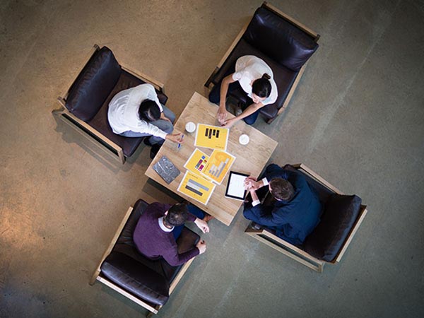 4 people sitting in chairs collaborating