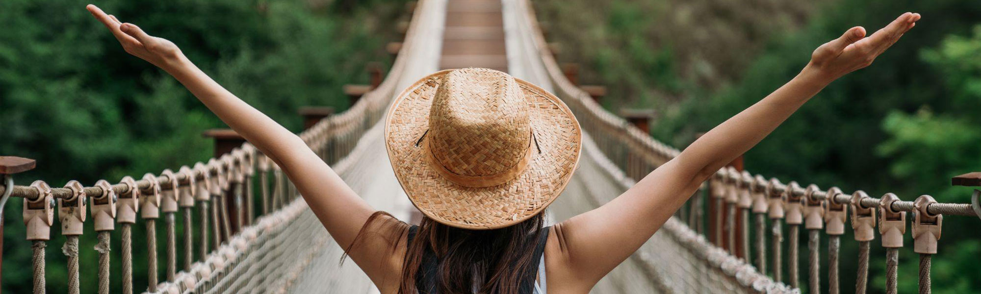 women standing before a bridge with arms outstretched