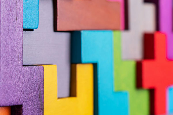 hands pushing together puzzle pieces