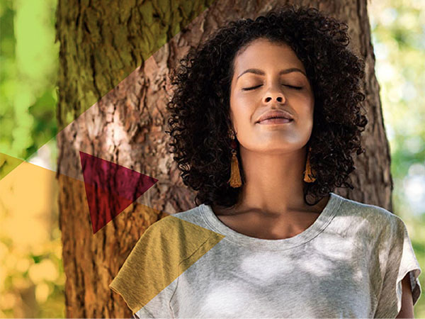 woman leaning against a tree trunk