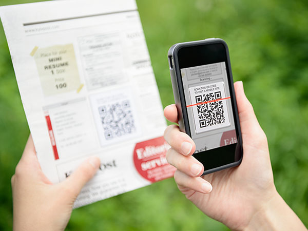 Woman scanning qr code from magazine.