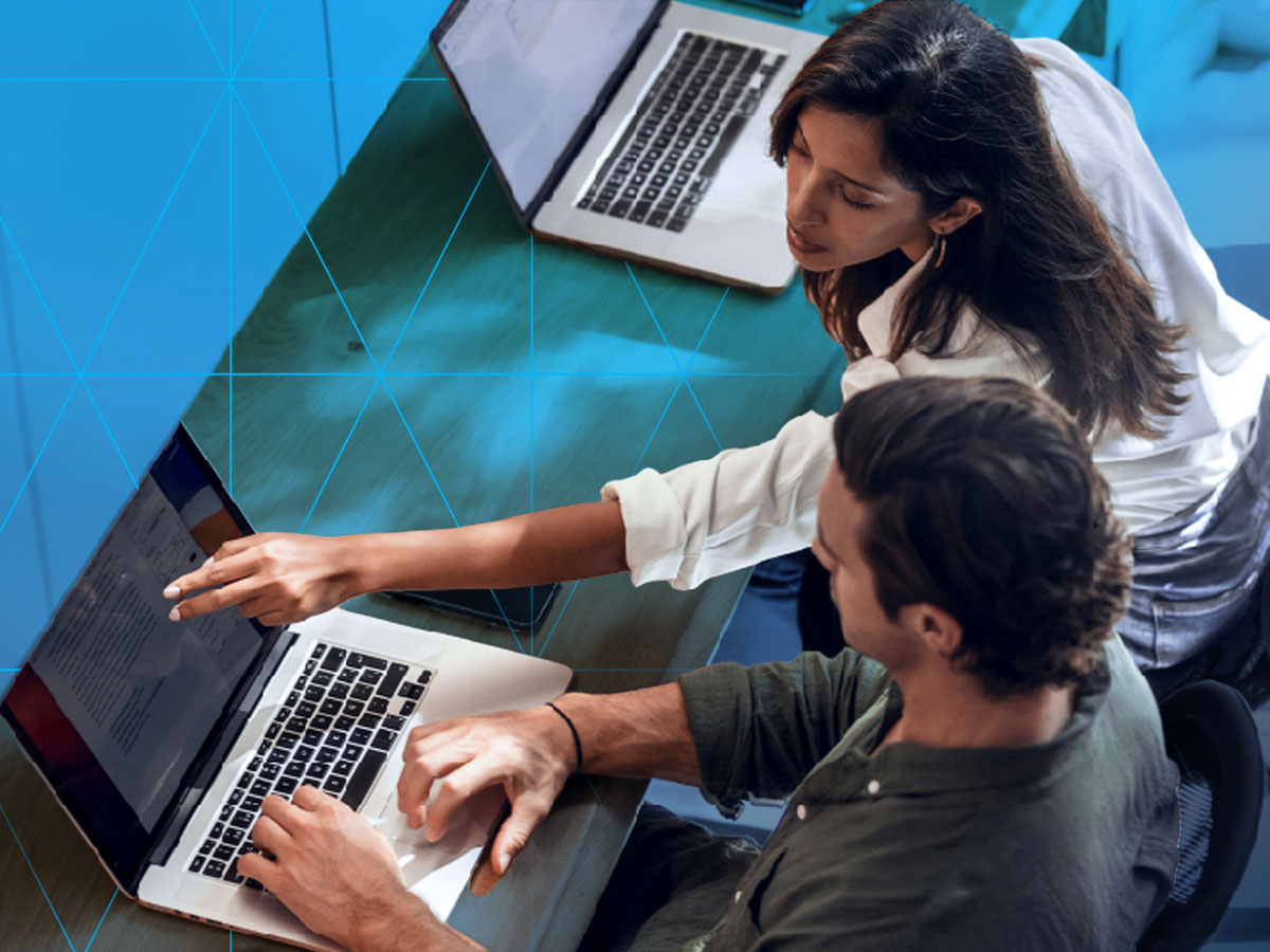 bird's eye view of two coworkers reviewing content on a laptop
