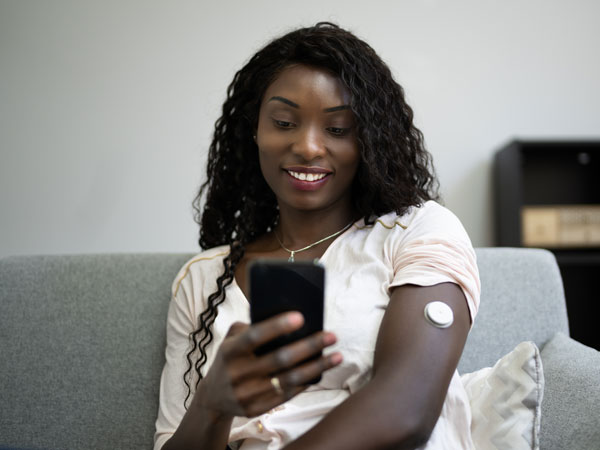 woman sitting on her couch with phone