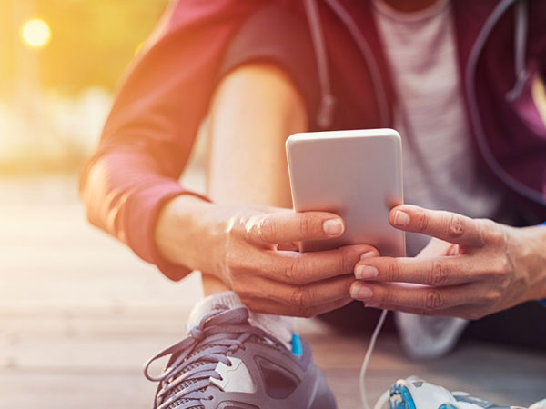 man wearing workout gear checking his phone
