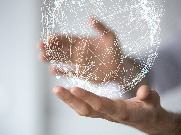 Hand holding a digital globe made of interconnected network lines.