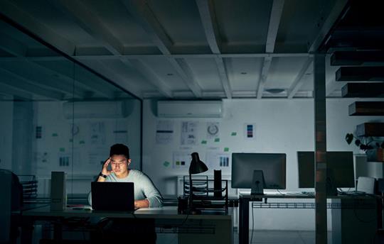 man sitting at his desk in a dark office