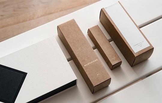 four plain small product packages lined up on a white table
